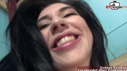 Sheril Blossom lächelt frech in die Kamera und präsentiert ihre großen nackten Brüste mit beiden Händen.