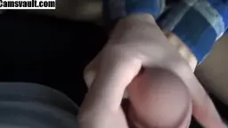 Blonde in offenem blauem Karohemd liegt lächelnd auf dem Bett, Brüste entblößt