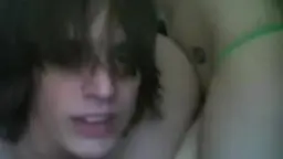 Junger Mann mit dunklem Haar und Brusttattoo schaut lustvoll in die Kamera, Oberkörper frei.