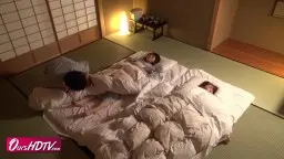 Junge Japanerin mit langen Haaren starrt schockiert auf das Geschehen, während ihre Mutter neben ihr sitzt.