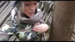 Blonde Camouflage-Jacke lehnt an Baum im Park