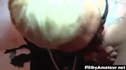 Dirty Tracy mit schwarzer Maske, Perlenkette und geöffnetem Mund vor einer alten Tür