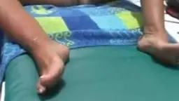Blonde Mutter liegt nackt auf buntem Handtuch, während der Opa ihre nackte Fotze mit beiden Händen spreizt