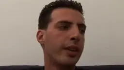 Geile braunhaarige Milf mit Perlenkette kniet vor jungem Mann und bläst ihm hingebungsvoll auf dem Sofa