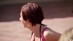 Reifer Mann mit dunklen Haaren lächelt entspannt auf roter Couch neben einer Frau.