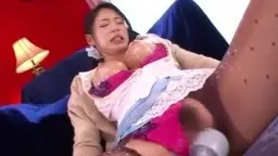Japanerin in pinkem BH und Strapsen liegt mit gespreizten Beinen auf blauem Sofa, während ein Mann ihre Milchbrüste bearbeitet