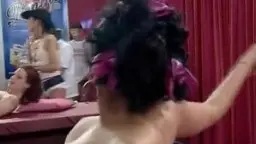 Nackte Brünette mit schwarzen Locken spreizt ihre nassen Beine weit auf einem roten Samtsofa