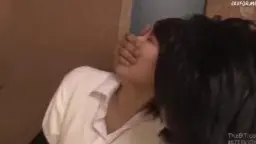 Japanischer Mann in grauem Shirt drückt junge Asiatin im weißen Hemd gegen raue Wand und küsst sie leidenschaftlich